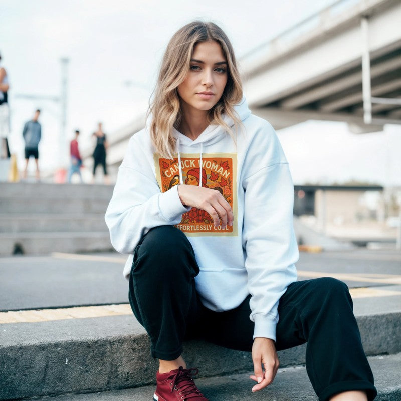 Woman wearing a white hoodie with a graphic design sitting on steps outdoors.