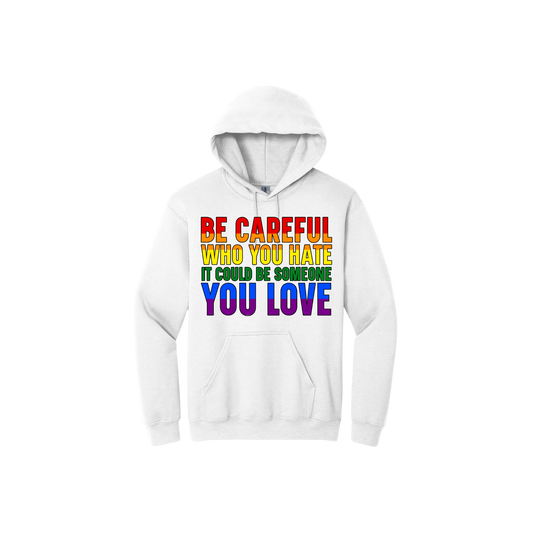 White hoodie with colourful text reading 'Be careful who you hate it could be someone you love'.