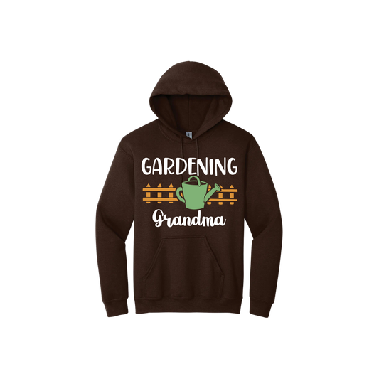 Brown unisex hoodie featuring white text reading 'Gardening Grandma' with graphics of a picket fence and a green watering can.