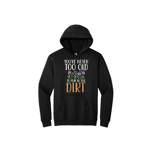 Black unisex hoodie with text that reads 'You're never too old to play in the dirt' along side graphics of flowers.