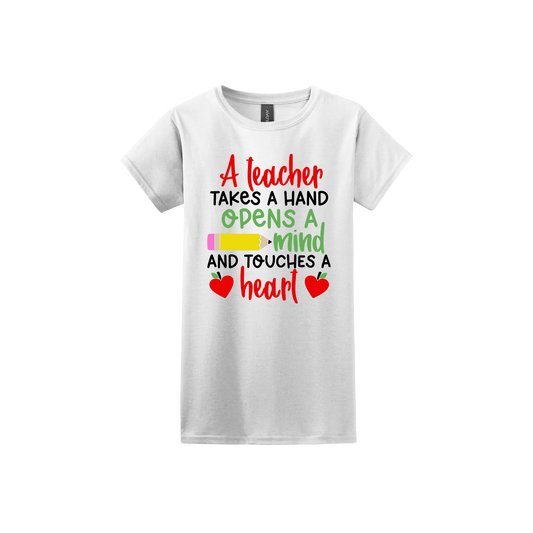 White womens tshirt with colorful text reading "A teacher takes a hand opens a mind and touches a heart". The design features a pencil and two apples in the shape of hearts.